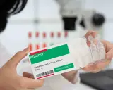 Ręce trzymają opakowanie z napisem "Albumin". To zastrzyk, który może pomóc w leczeniu.
