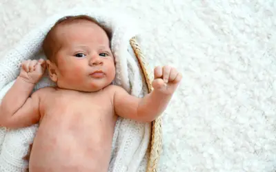 Niemowlę z zaczerwienioną skórą, być może objaw uczulenia na jajka u niemowląt.